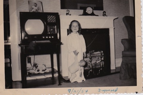 Memoo at age three, standing by the fireplace